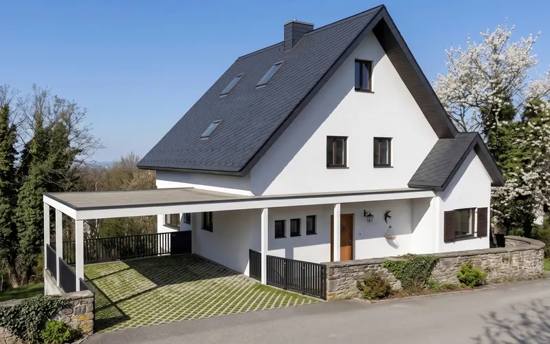 Bestandshaus mit Satteldach und neuem Vordach über der Terrasse